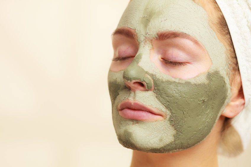 Woman face with green clay mud mask