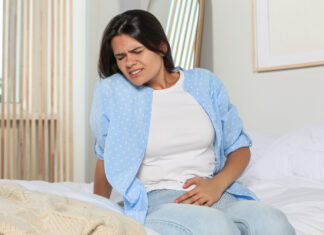 Infecciones urinarias: prevención natural y hábitos saludables infecciones urinarias Young woman suffering from cystitis on bed at home