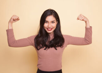 Usos de la creatina més enllà de l’esport Beautiful young Asian woman flex bicep on beige background