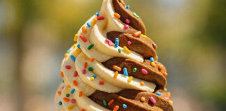 Tentempiés saludables en verano: cómo alimentar e hidratar a los más pequeños Ice cream cone in female hand with colorful sprinkles on it.
